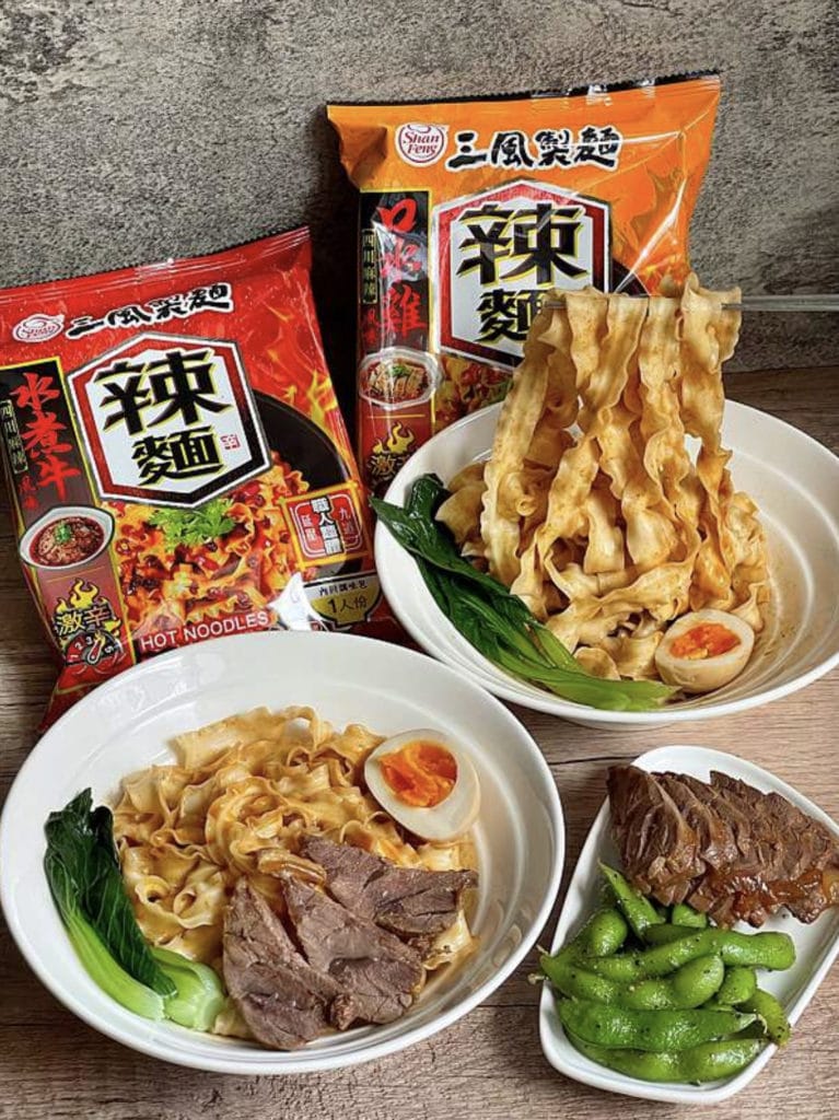 口水雞風味拌麵與水煮牛風味拌麵以白碗盛裝，搭配翠綠蔬菜與軟嫩水煮蛋，色澤迷人香氣四溢