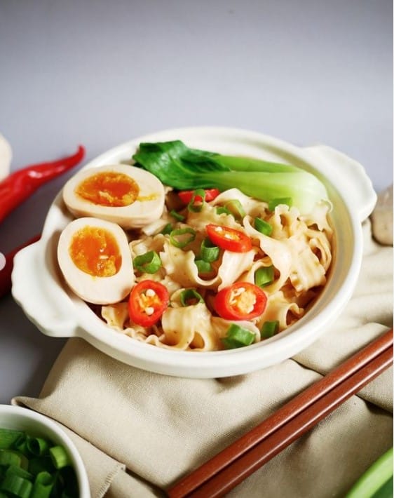 一碗麵上面鋪滿蔥花、蛋、青江菜